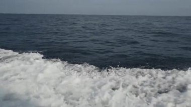 Endonezya'da deniz ufuk çerçevede bir motorlu tekne dalgalardan.