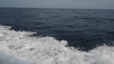 Endonezya'da deniz ufuk çerçevede bir motorlu tekne dalgalardan.
