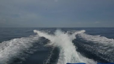 Endonezya'da deniz ufuk çerçevede bir motorlu tekne dalgalardan.