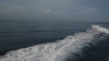 Endonezya'da deniz ufuk çerçevede bir motorlu tekne dalgalardan.