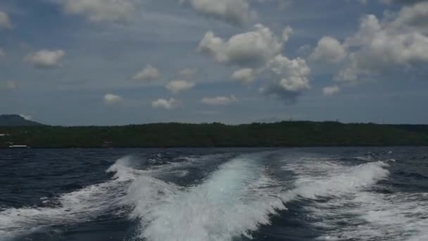 Vågorna från en motorbåt mot en bakgrund av havet horisonten i Indonesien. — Stockvideo