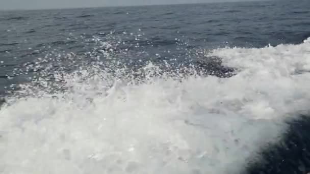 Vågorna från en motorbåt mot en bakgrund av havet horisonten i Indonesien. — Stockvideo