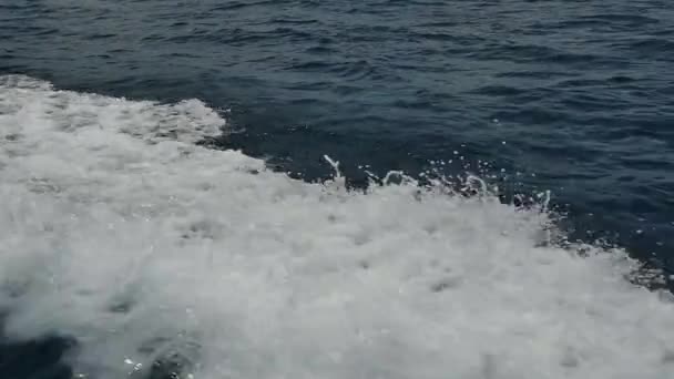 Белая морская пена и пузырьки волн, исходящих от движения моторной лодки . — стоковое видео
