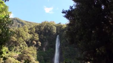 Güç su şelale bir kayalık sahil ve dağların Yeni Zelanda.