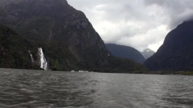 Güç su şelale bir kayalık sahil ve dağların Yeni Zelanda.