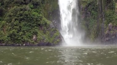 Güç su şelale bir kayalık sahil ve dağların Yeni Zelanda.