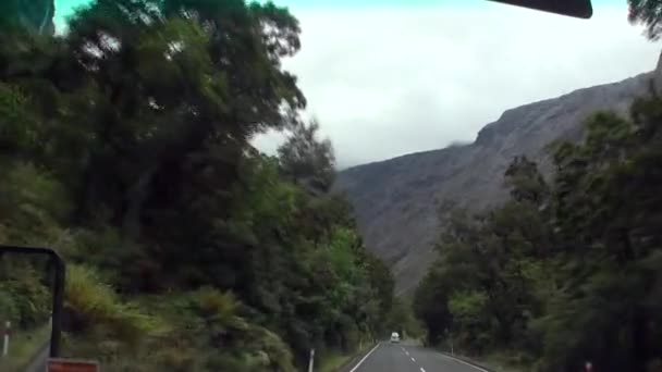 Carretera en verdes montañas vista desde la ventana del coche en Nueva Zelanda . — Vídeos de Stock