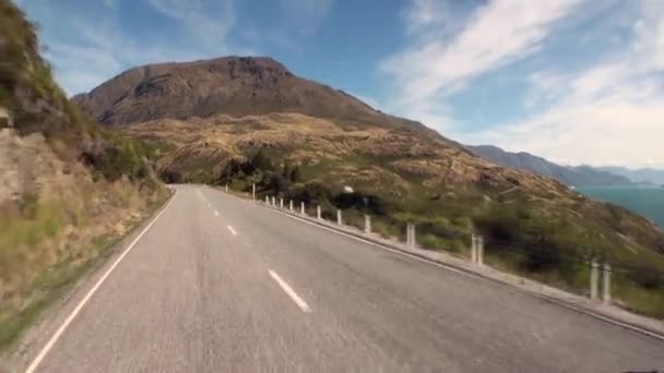 Vista panorámica de la carretera en la costa del océano desde la ventana del coche en Nueva Zelanda . — Vídeos de Stock