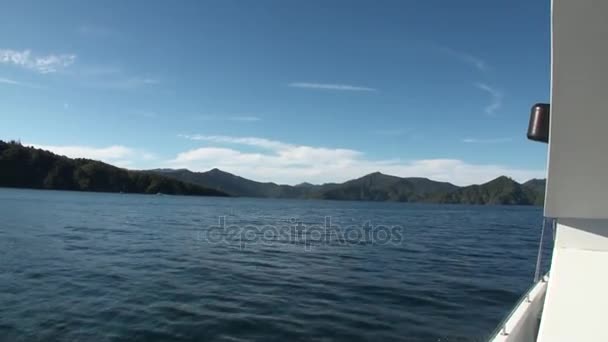 Green mountains and calm ocean water view from a moving yacht in new Zealand. — Stock Video