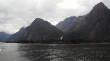 Su yüzeyi Yeni Zelanda kar dağ panorama arka peyzaj.