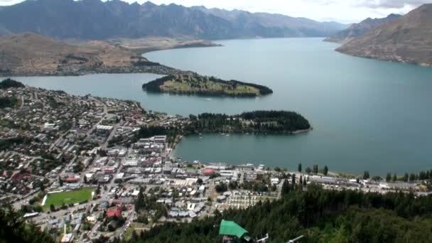 Házak-óceán partján, a háttérben a zöld hegyek és a víz, Új-Zéland. — Stock videók