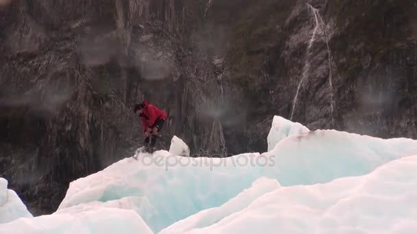 Bergbeklimmer man breekt het ijs op de gletsjer in besneeuwde koude bergen van Nieuw-Zeeland. — Stockvideo