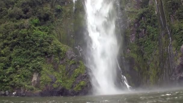 Cachoeira na costa rochosa verde e montanhas Nova Zelândia . — Vídeo de Stock