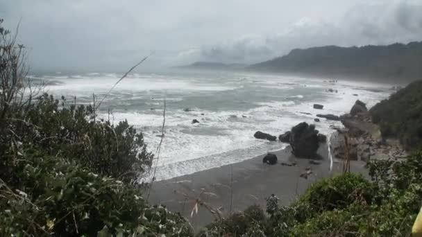 Vlny na skalnatém pobřeží a hory Nového Zélandu. — Stock video