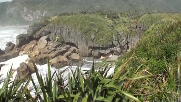 Ondas em uma costa rochosa e montanhas Nova Zelândia . — Vídeo de Stock