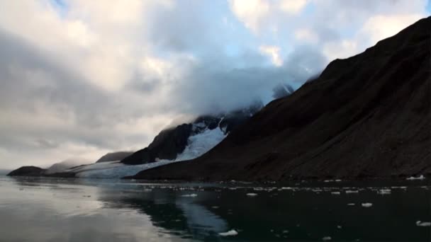 스발바르에서 북극 바다의 물에 산의 배경에 빙원을 이동. — 비디오