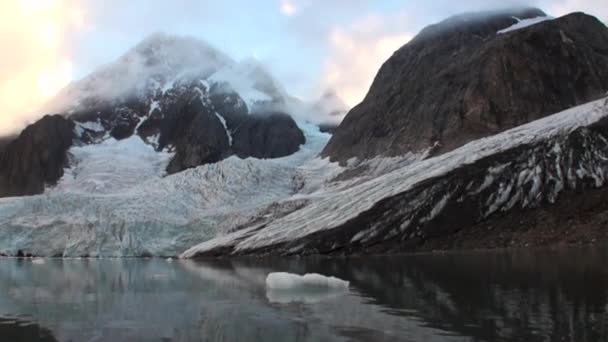 Bewegte Eisschollen auf dem Hintergrund des Berges auf dem Wasser des arktischen Ozeans in Spitzbergen. — Stockvideo