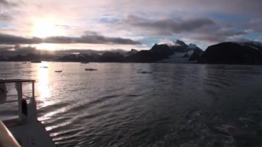 Arktik Okyanusu su Svalbard dağda arka plan üzerinde arkasında gemisiyle.
