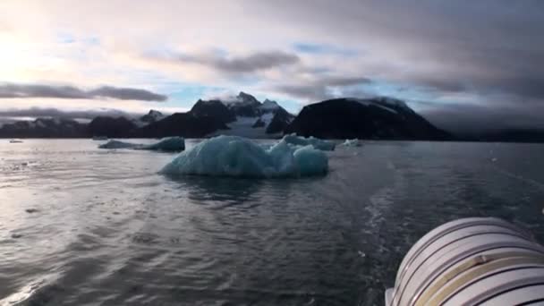 Bewegte Eisschollen auf dem Hintergrund des Berges auf dem Wasser des arktischen Ozeans in Spitzbergen. — Stockvideo