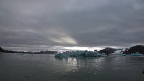 Sonnenuntergang vor dem Hintergrund schneebedeckter Eisberge des arktischen Ozeans in Spitzbergen. — Stockvideo