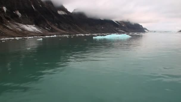 Flytta isflak på bakgrund av berg på vattnet i Arktiska oceanen i Svalbard. — Stockvideo