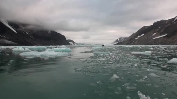 Bewegte Eisschollen auf dem Hintergrund des Berges auf dem Wasser des arktischen Ozeans in Spitzbergen. — Stockvideo