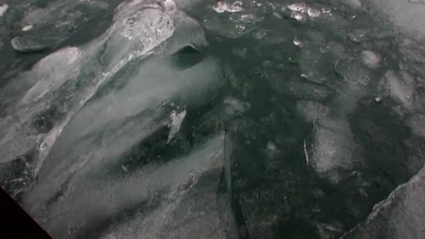 Bewegte Eisschollen auf dem Hintergrund des Berges auf dem Wasser des arktischen Ozeans in Spitzbergen. — Stockvideo