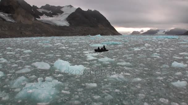 Люди на лодке плывут на заднем плане Перемещение ледяных полей Северного Ледовитого океана на Шпицбергене . — стоковое видео