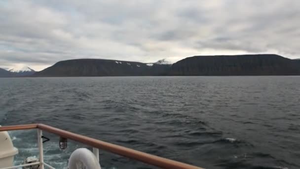 Back of the ship in water of Arctic Ocean on background of mountain in Svalbard. — Stock Video
