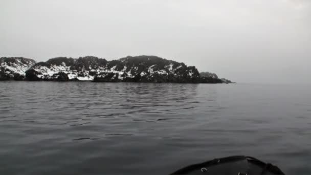 La costa rocosa montañosa al fondo del agua del Océano Ártico en Svalbard . — Vídeos de Stock