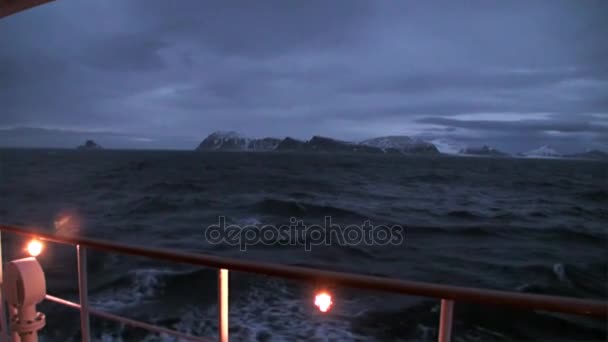Schiffsrückseite in der Nacht auf dem Hintergrund des Berges auf dem Wasser des arktischen Ozeans. — Stockvideo