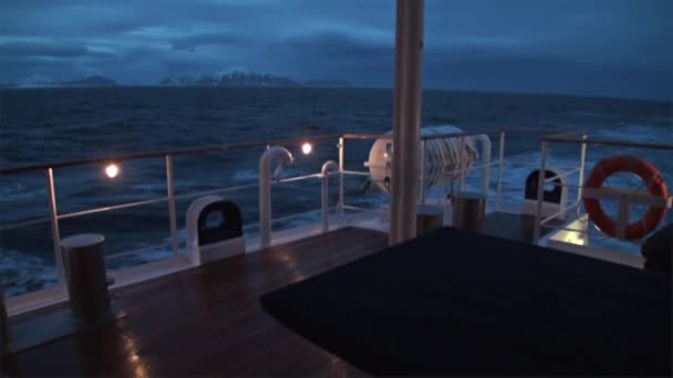 北極海の水で山の背景に夜の船の裏. — ストック動画