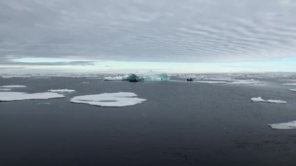 Λαστιχένιες βάρκες με δύτες επιπλέουν κοντά παγόβουνα, πάγου στον Αρκτικό Ωκεανό. Μεγέθυνση. — Αρχείο Βίντεο