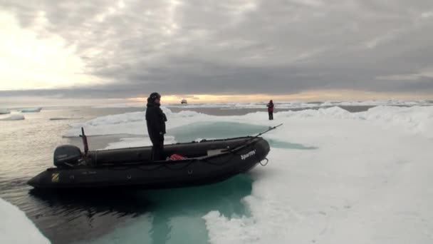 Mensen in de rubberboot dobbert op de achtergrond van de ijsbergen, ijs, in de Noordelijke IJszee. — Stockvideo