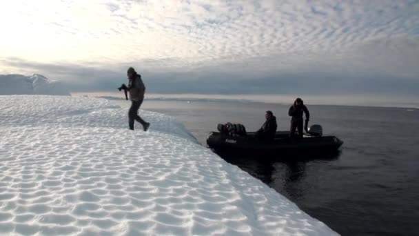 在北极的冰海洋背景上的橡皮船上的人. — 图库视频影像