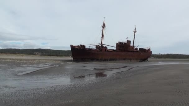 Rusty wreckage shipwreck on deserted shore beneaped dried-up ocean. — Stock Video