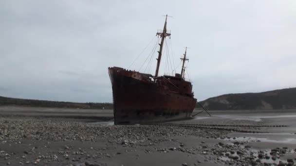 Rusty wreckage shipwreck on deserted shore beneaped dried-up ocean. — Stock Video