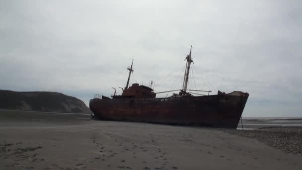 Rusty wreckage shipwreck on deserted shore beneaped dried-up ocean. — Stock Video