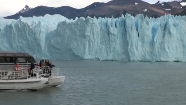 Az emberek a csónakban, havas hegyek és a jéghegyek az Antarktisz közelében. — Stock videók