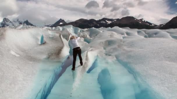 南極の雲の背景に氷河の雪に覆われた山の人々. — ストック動画