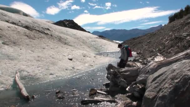 Les gens coulent de la glace fond dans les montagnes enneigées en Antarctique . — Video