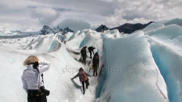 Les gens dans les montagnes enneigées sur le glacier sur fond de nuages en Antarctique . — Video