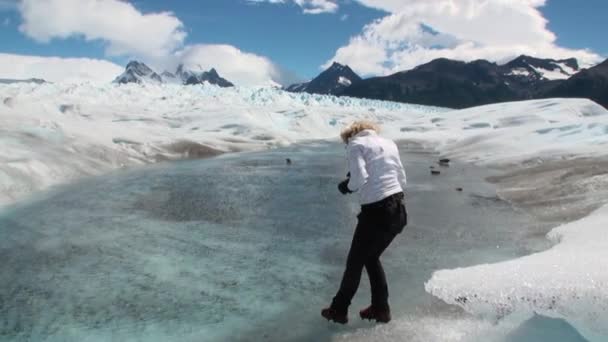 Mädchen am Wasser in schneebedeckten Bergen auf Gletscher in der Antarktis. — Stockvideo