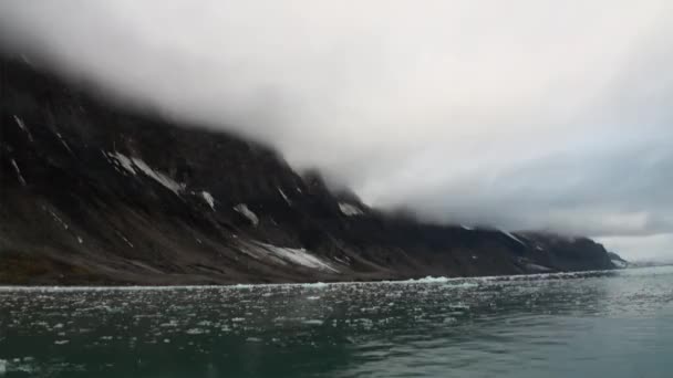 Mozgó jégtáblák, háttérben a hegy, a víz, a Jeges-tenger, a Svalbard. — Stock videók