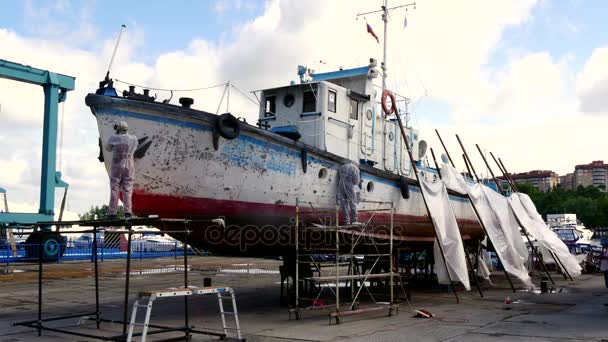 La gente feriale strappa la vernice in processo di riparazione di nave marittima fluviale a cantiere navale . — Video Stock