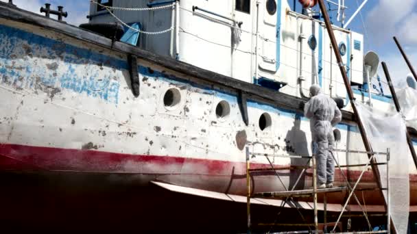 Workers tear off paint on metal in repairs process at shipyard. — Stock Video