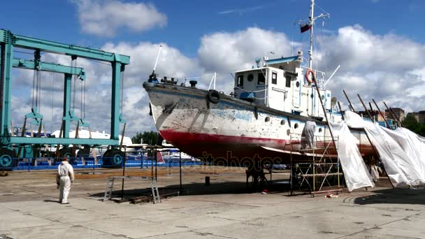 Работники сорвали краску в процессе ремонта речного морского судна на верфи . — стоковое видео