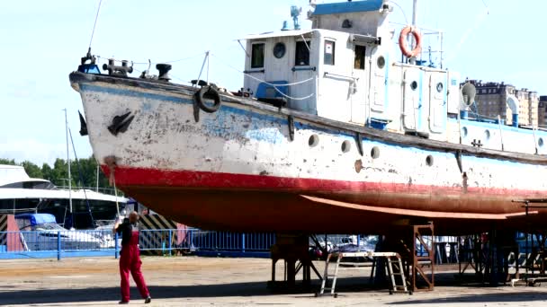 Il lavoratore lava la nave dopo la pulizia con la mola nel cantiere navale in porto . — Video Stock