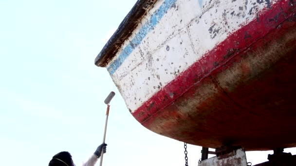 Il lavoratore copre il metallo con una vernice di fondo di vecchia nave arrugginita a cantiere navale in porto . — Video Stock