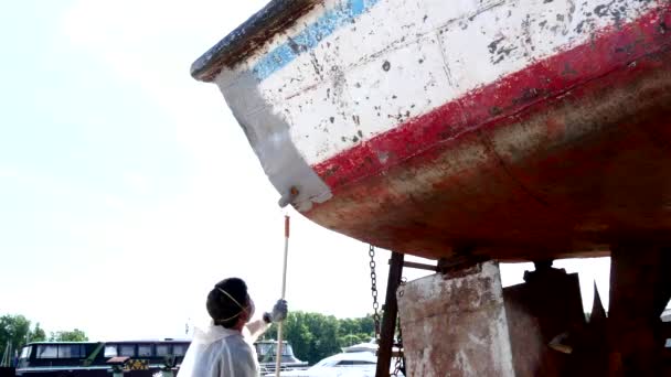 Arbeiter überzieht altes rostiges Schiff auf Werft im Hafen mit Grundierung. — Stockvideo